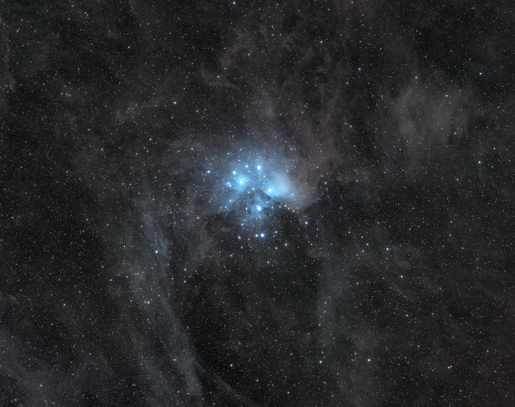 The Seven Sisters open cluster wrapped in blue reflection nebulosity and fine interstellar dust.