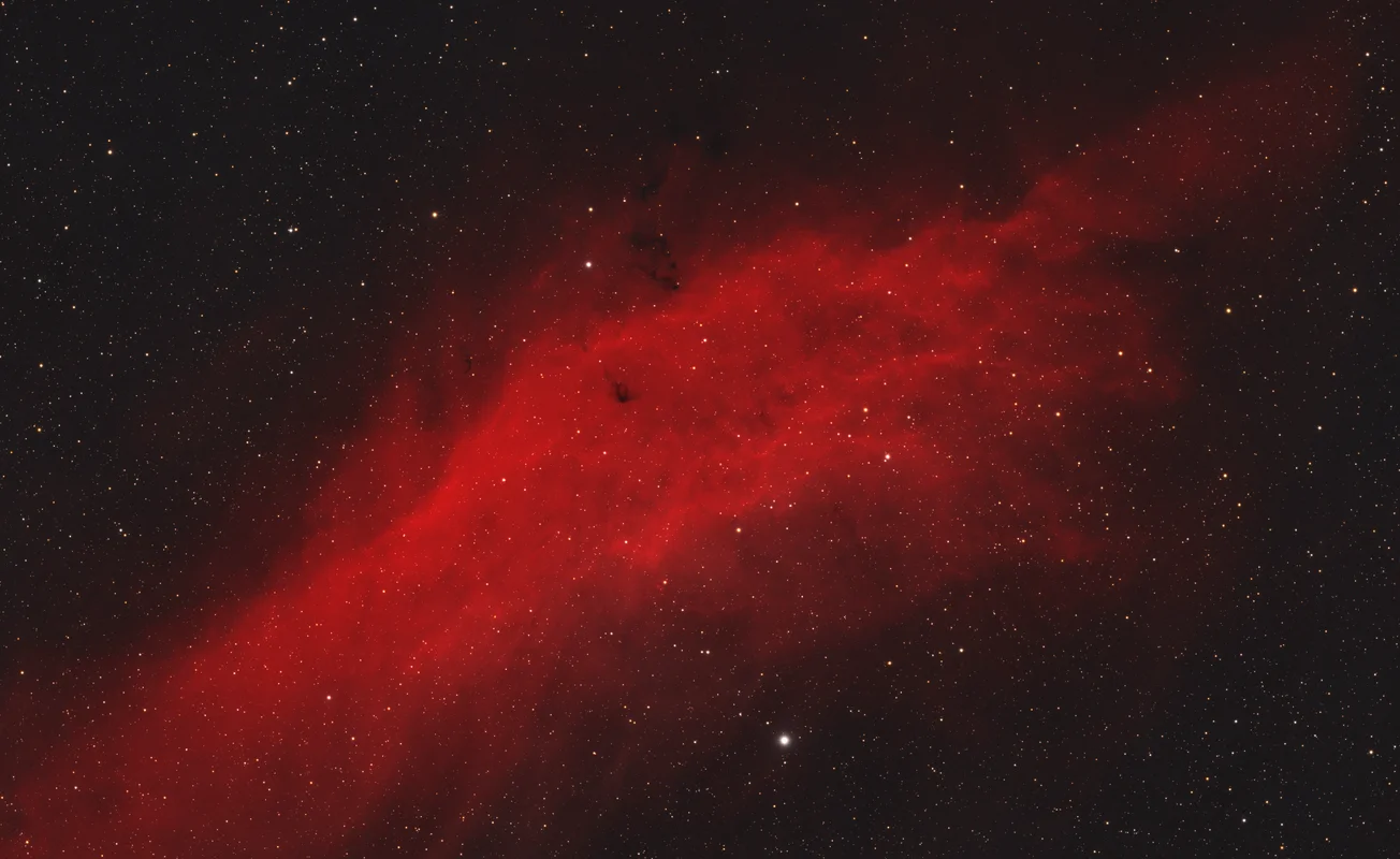 A wide hydrogen-alpha rich emission nebula in Perseus, shaped by energetic radiation from nearby stars.